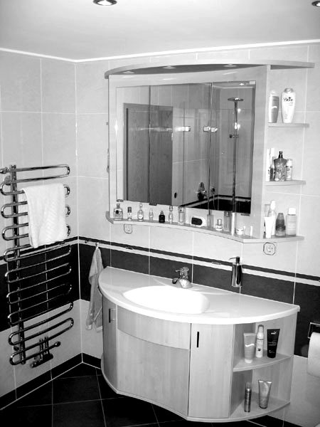 Waschtisch mit Spiegelschrank und Handtuchheizkörper in einem Referenzbad